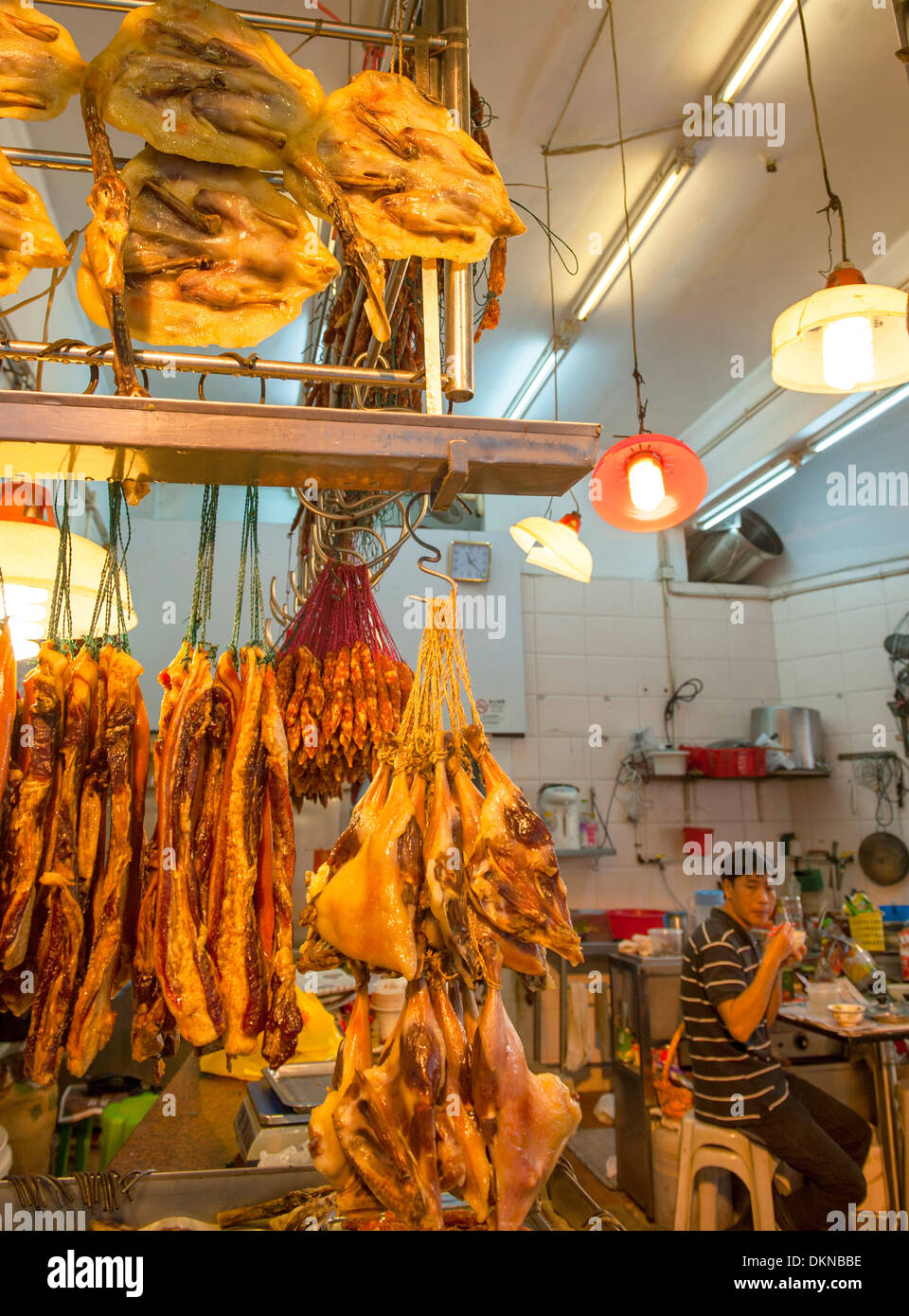 Duck shop with vendor eating at lunchtime in a market street of Macau's world heritage old town, China Stock Photo