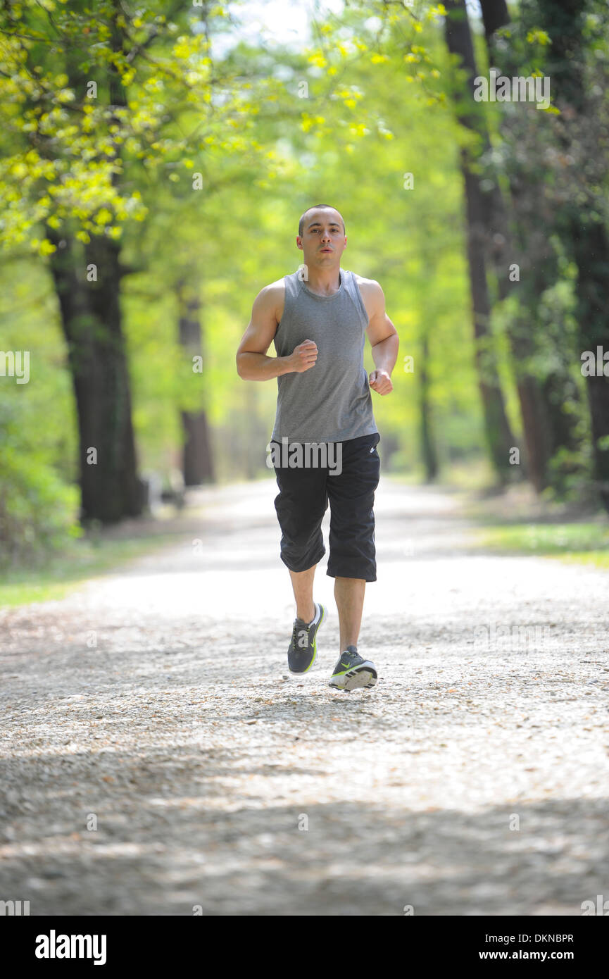 Young man running in park hi-res stock photography and images - Alamy