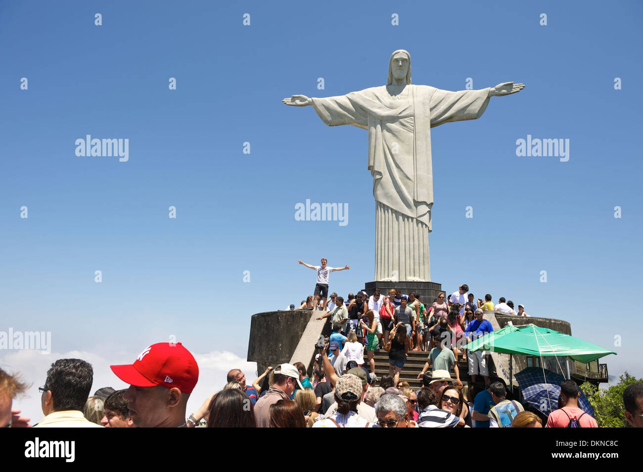 Crowds of tourists visiting the Christ monument at Corcovado posing with outstretched arms Rio de Janeiro Brazil Stock Photo