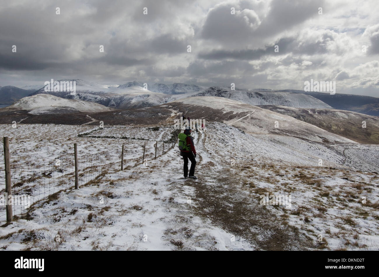 A group of friends dog walking in a snow shower, climbing down from ...