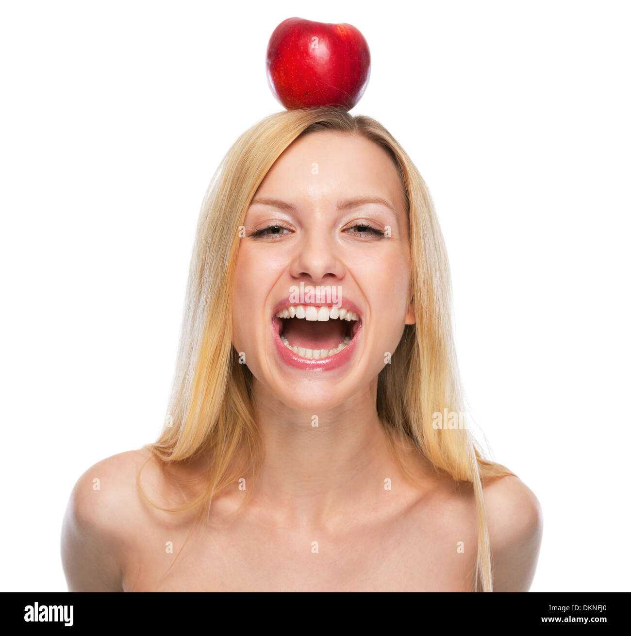 Portrait of smiling teenage girl with apple on head Stock Photo