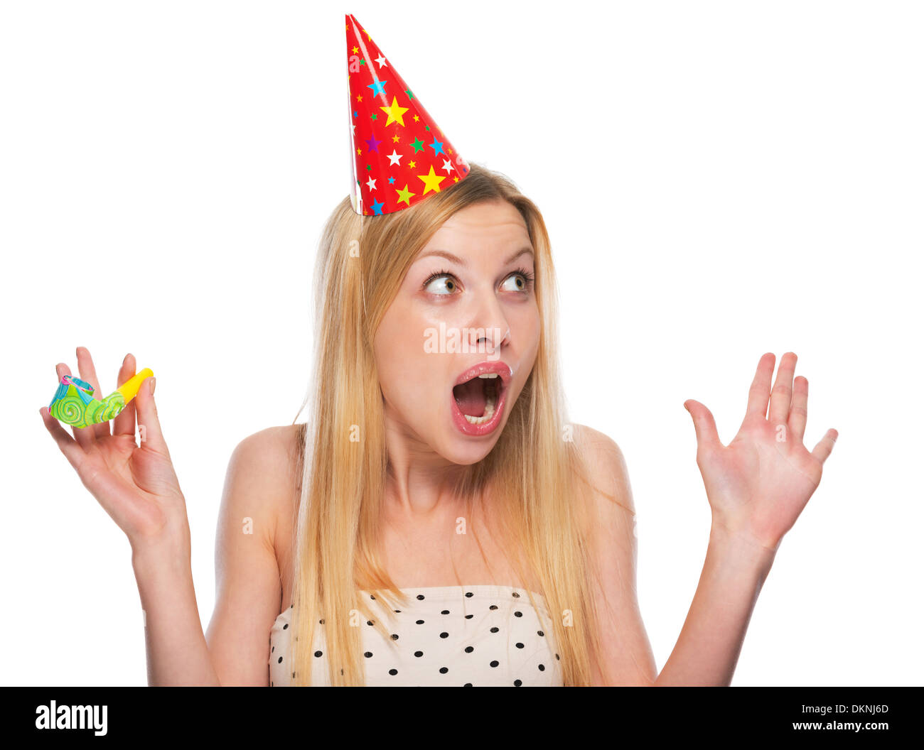 Portrait of surprised teenage girl in cap with party horn blower ...
