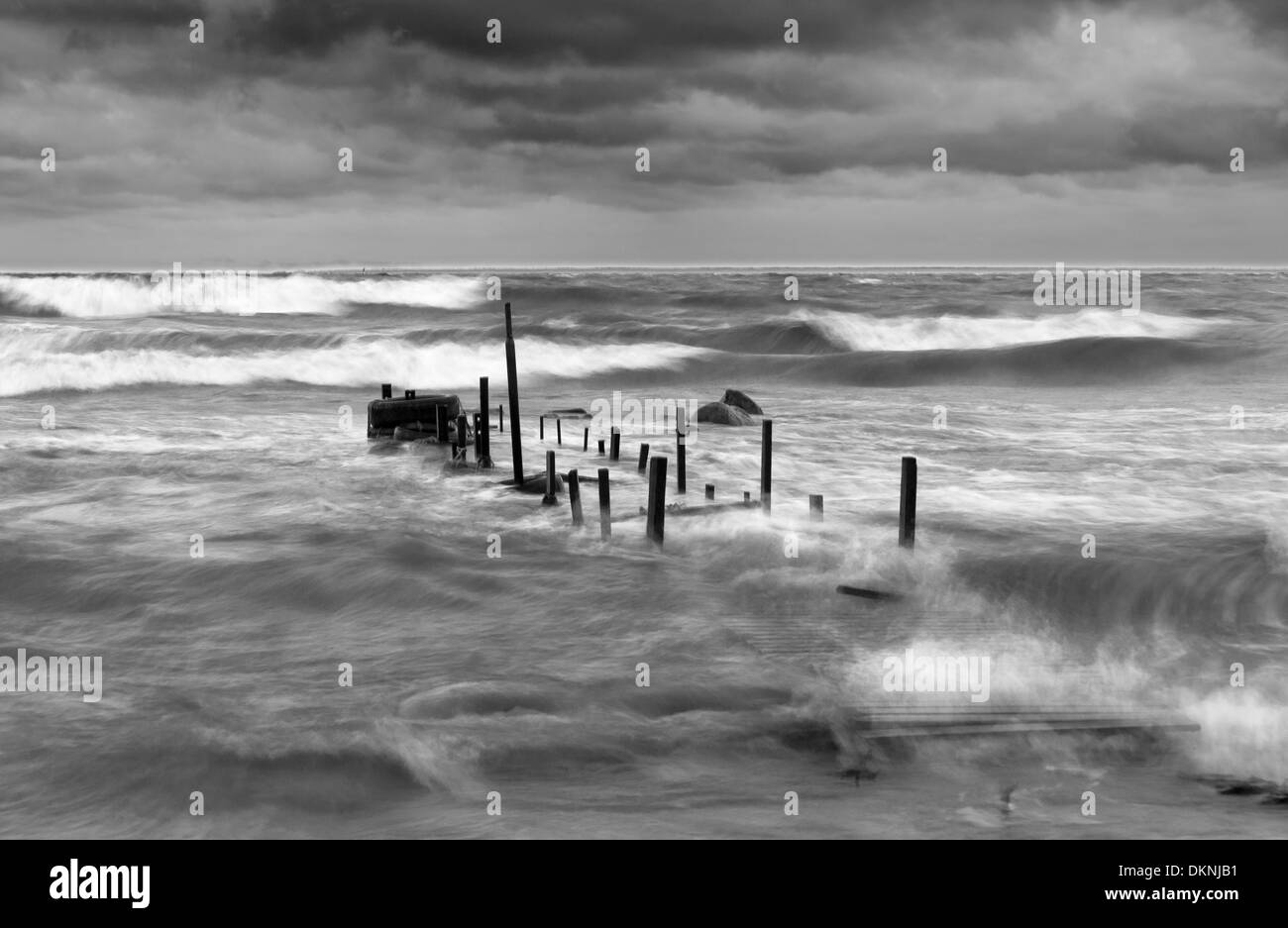 Wooden bridge in a stormy and wavy sea Stock Photo