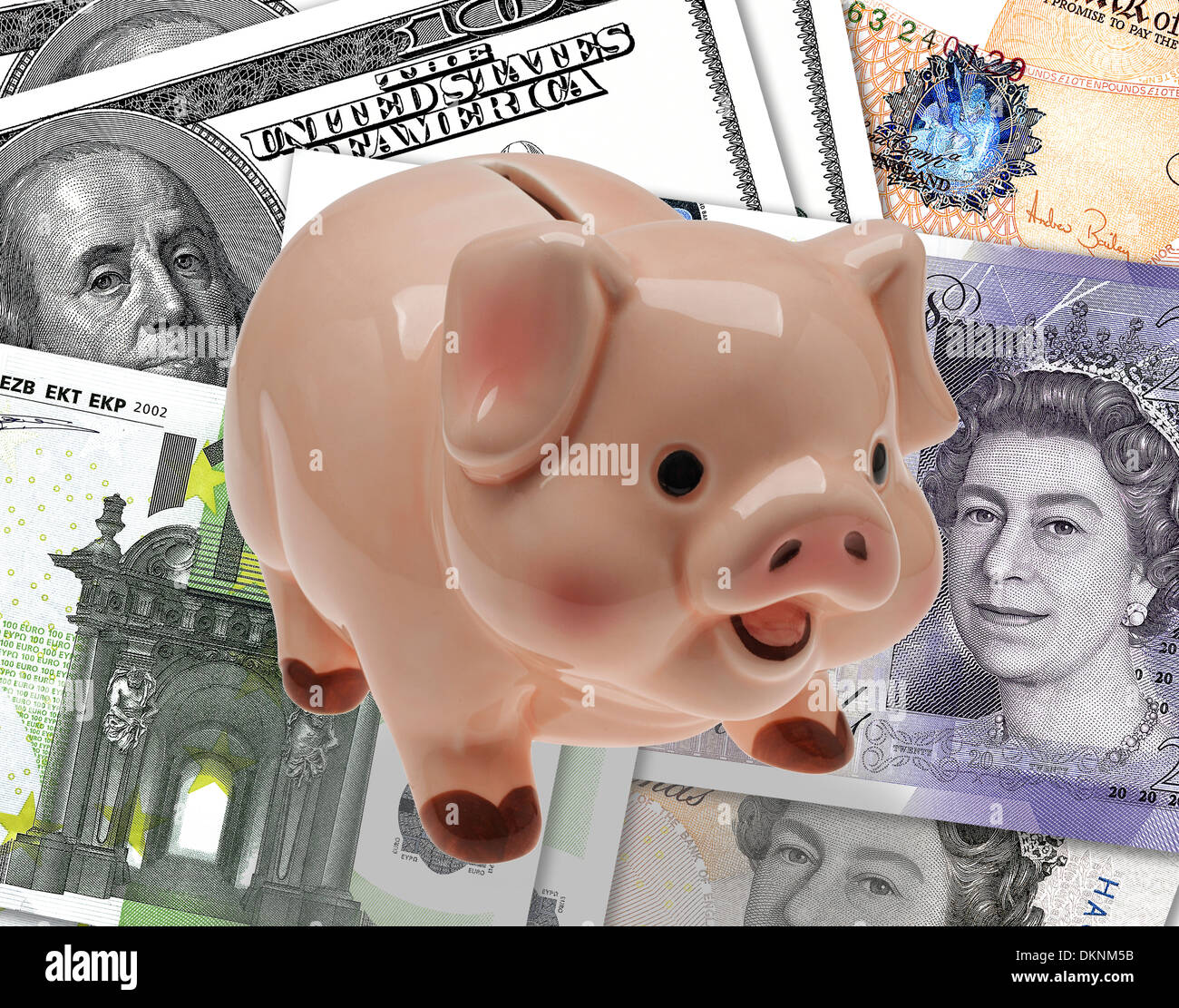 China/ceramic child’s savings or piggy bank on background of pound, euro and dollar currency. Stock Photo