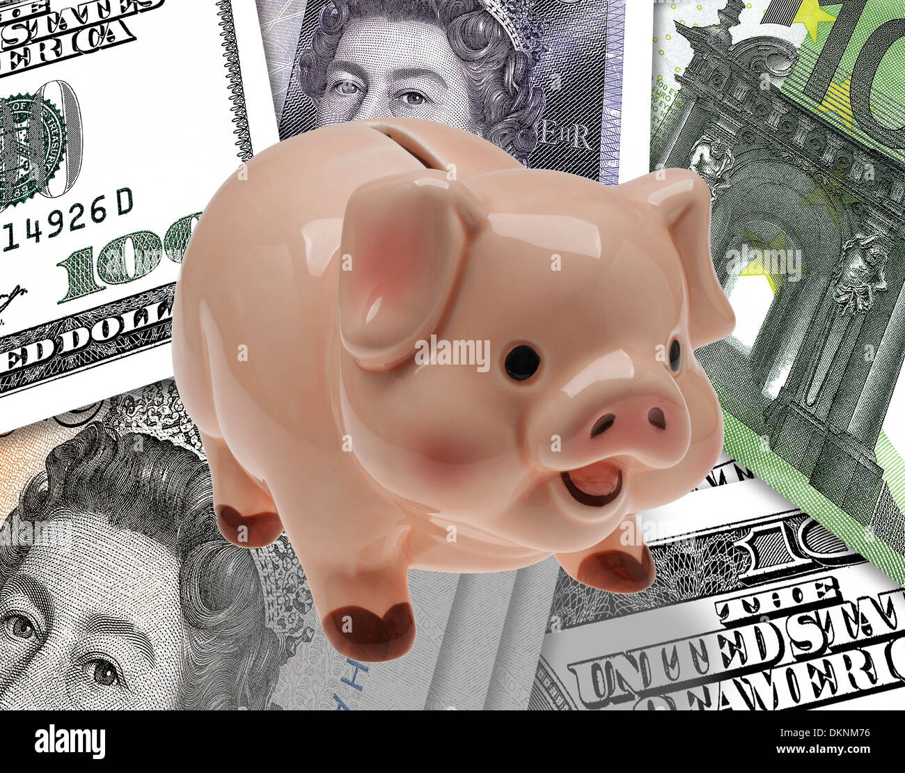 China/ceramic child’s savings or piggy bank on background of pound, euro and dollar currency. Stock Photo
