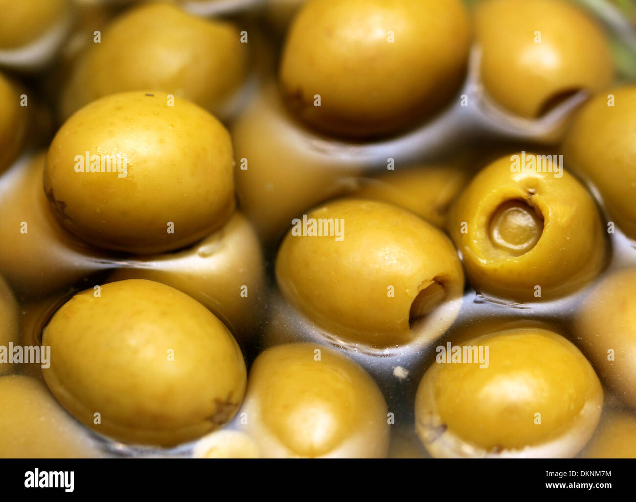 Green olives in liquid Stock Photo Alamy