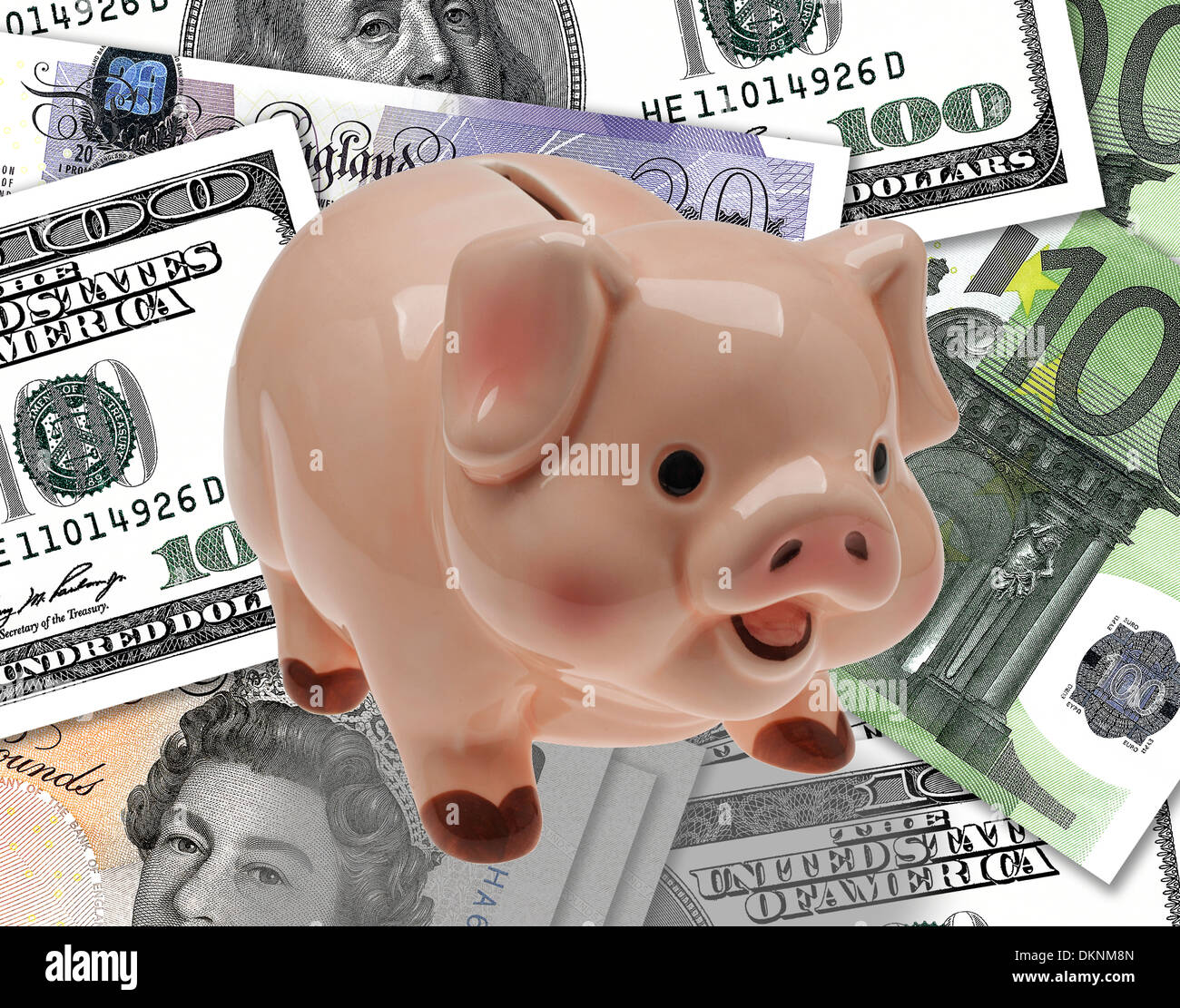 China/ceramic child’s savings or piggy bank on background of pound, euro and dollar currency. Stock Photo