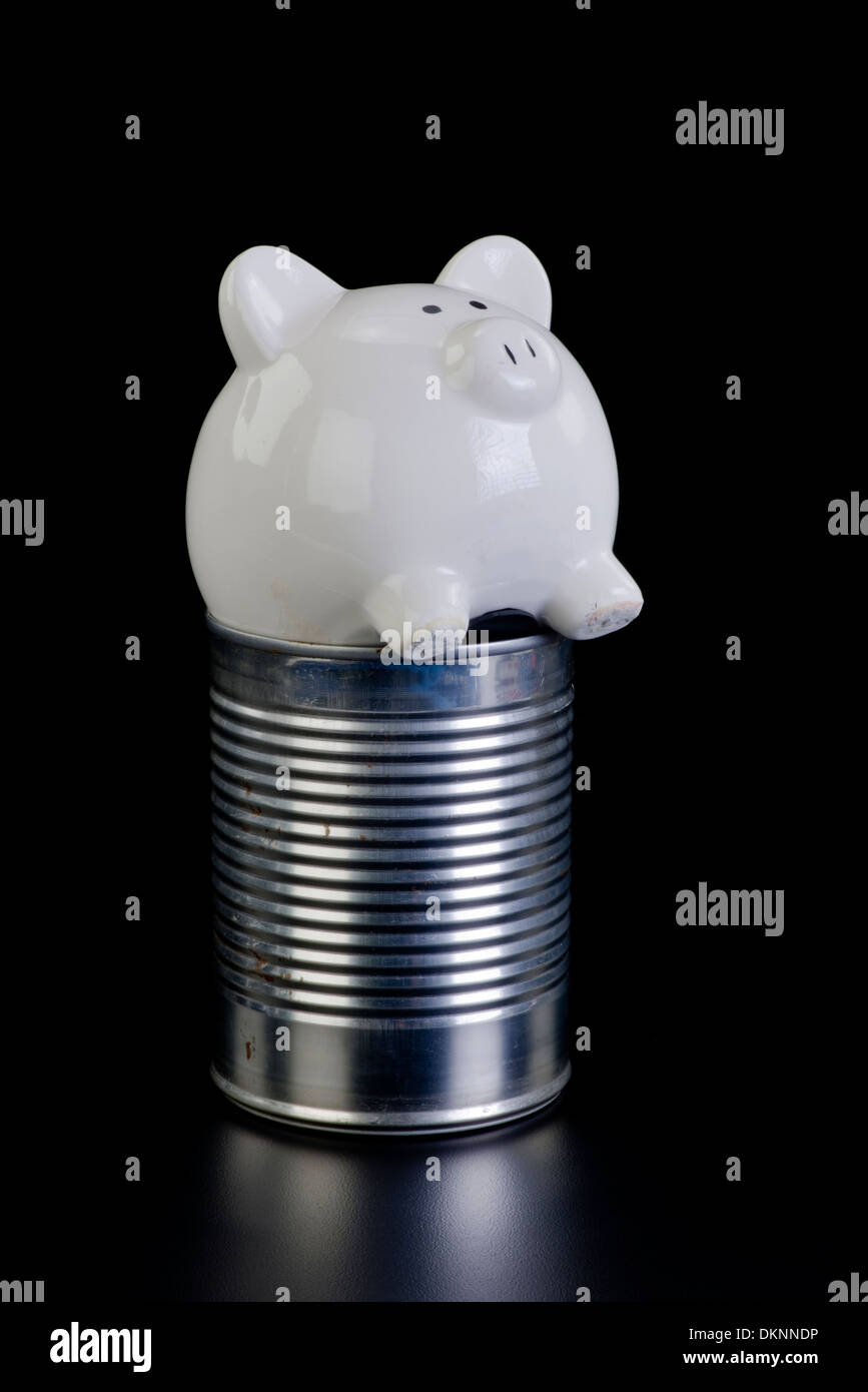 Piggy bank in the tin can of hard times. Stock Photo