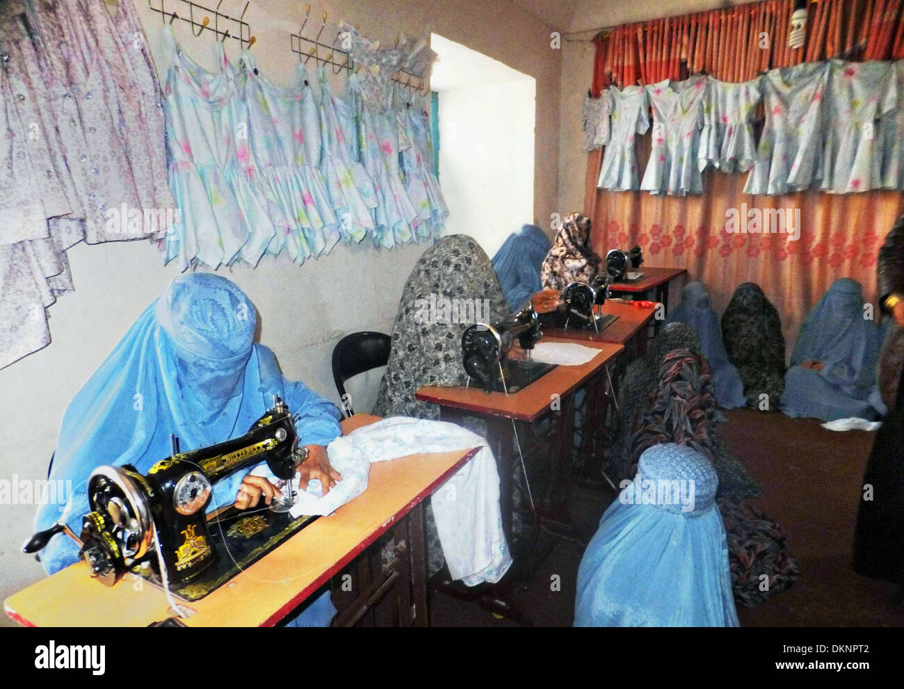 Afghan women wearing traditional full body covers known as burqa learn