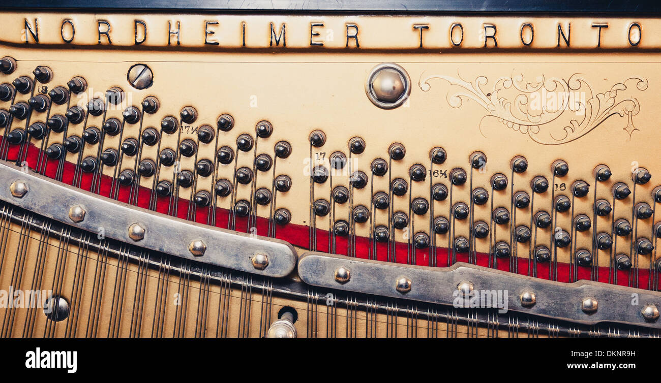 Strings, tuning pegs and soundboard on an old upright Nordheimer piano. Stock Photo