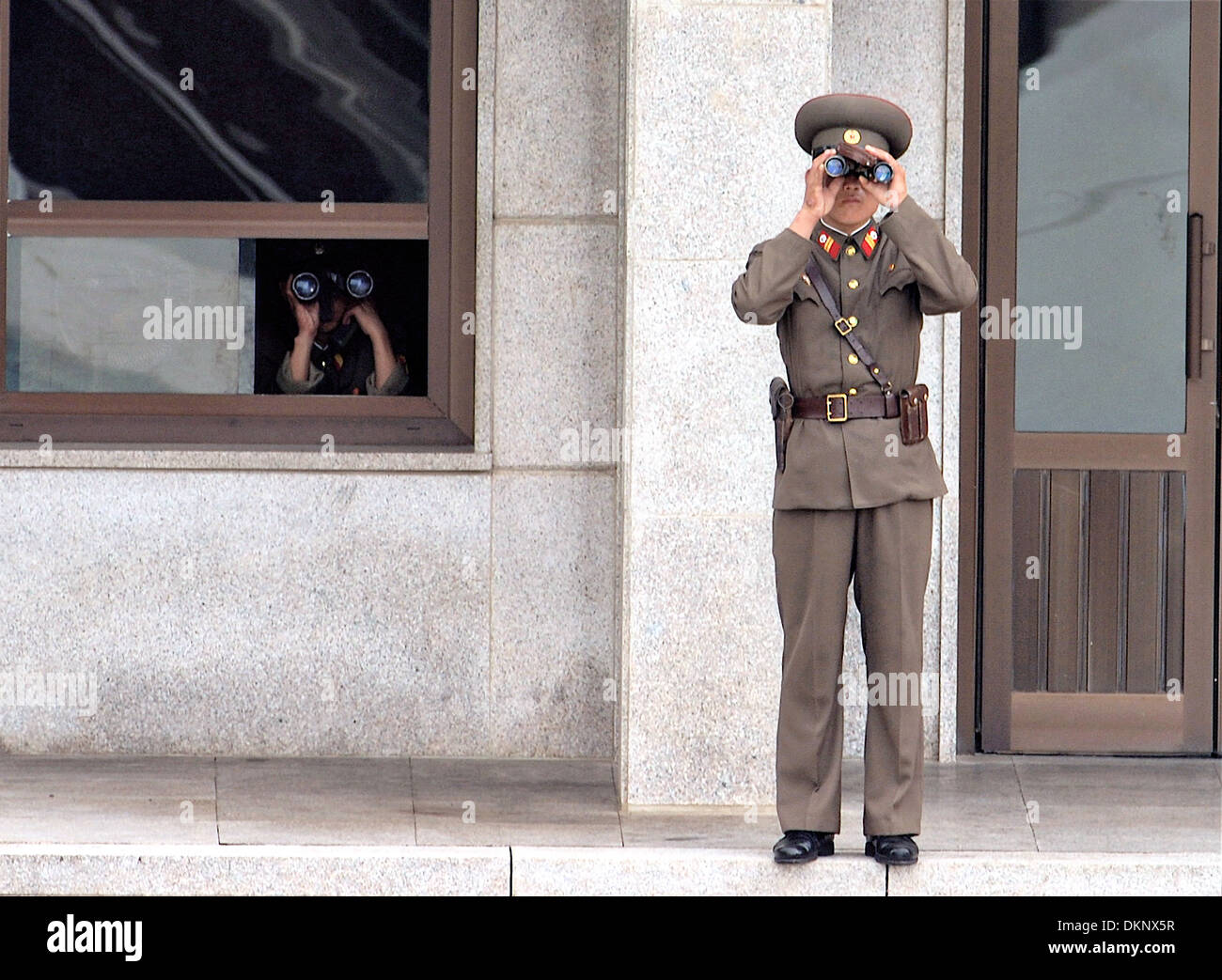 North Korean soldiers look toward the Joint Security Area also known as the Truce Village with binoculars along the DMZ August 25, 2007 in Panmunjom, South Korea. Stock Photo