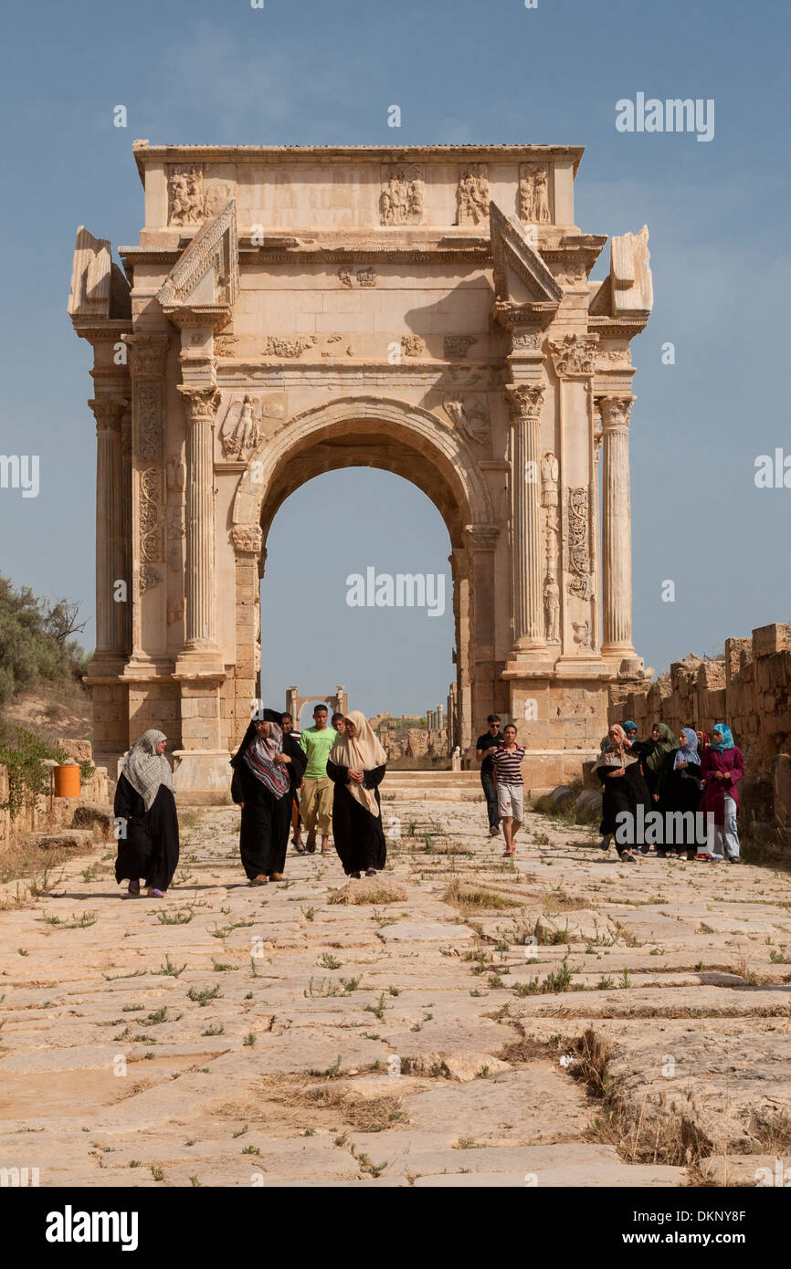 Libya, Leptis Magna. Libyan Women Walking Past the Arch of Marcus Aurelius. Stock Photo
