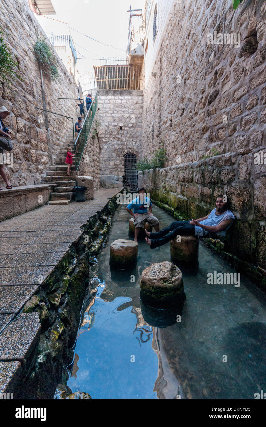 Jerusalem, Israel. Two young men sit on ancient stones outside Hezekiah