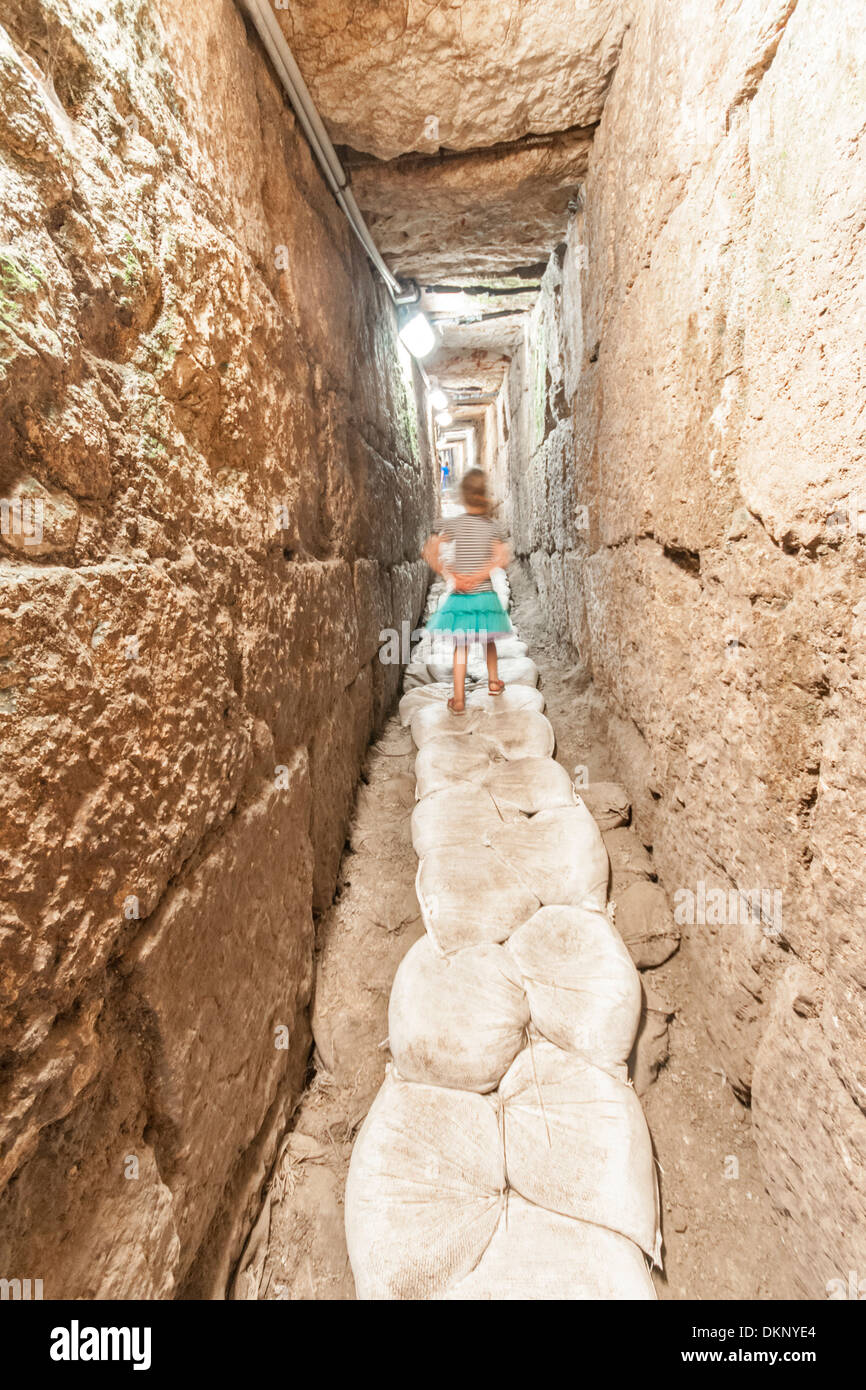Jerusalem, Israel. A young girl runs in the underground tunnel in the "City of David" the