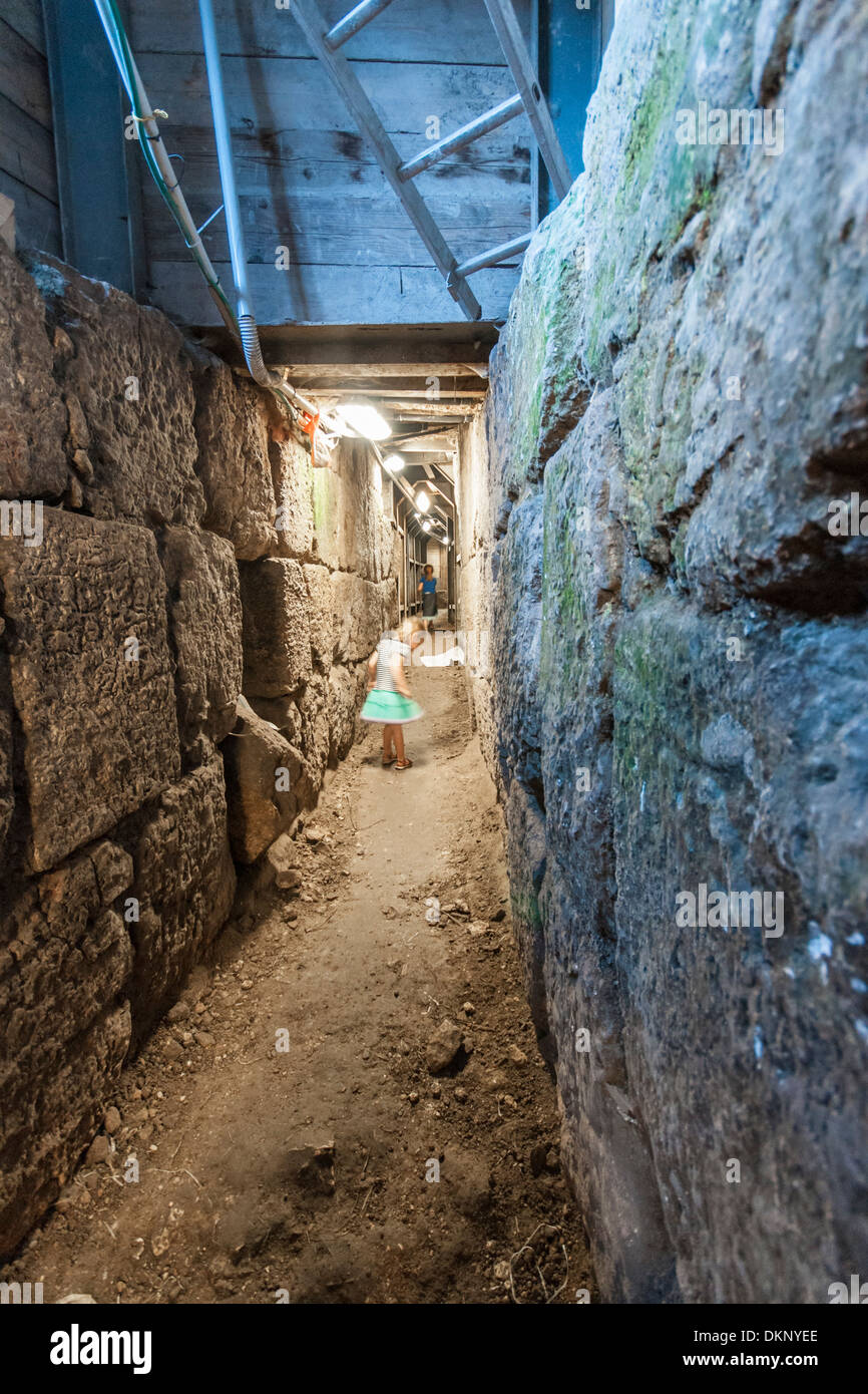 Jerusalem, Israel. A young girl runs in the underground tunnel in the "City of David" the