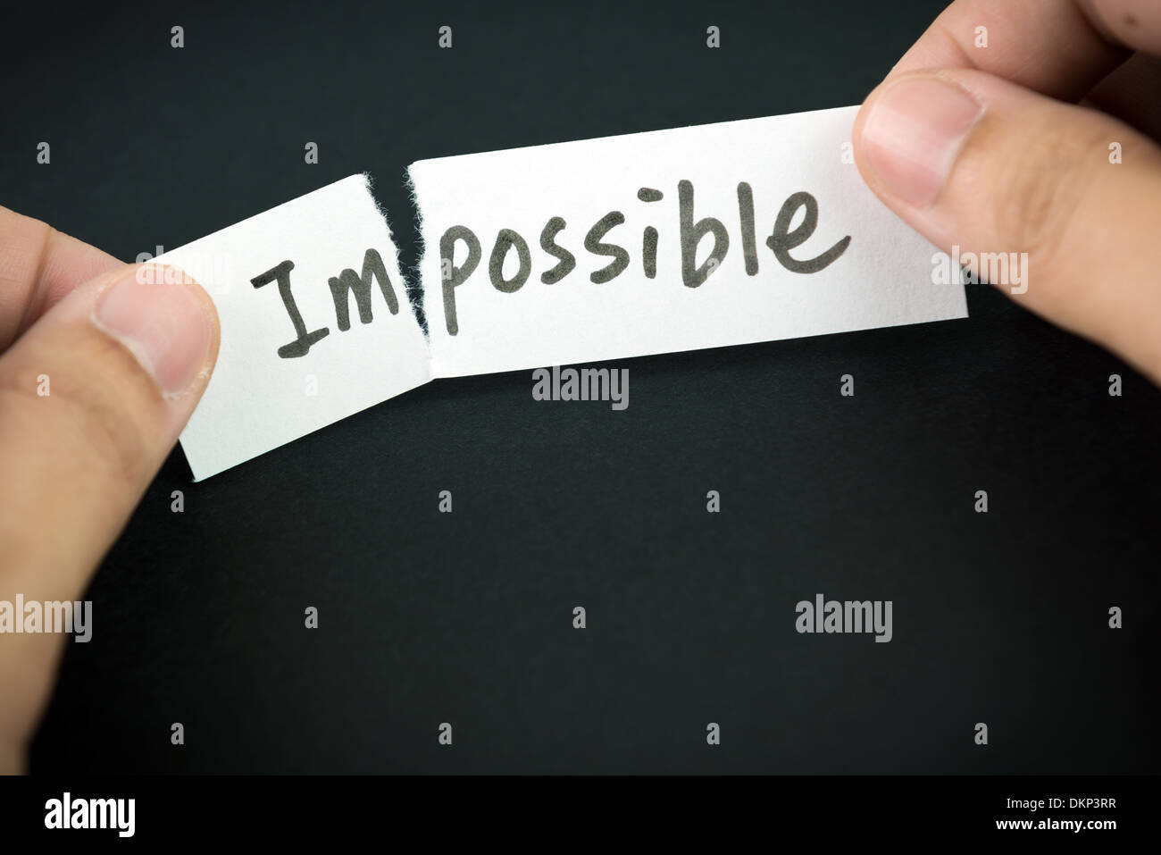 Tearing the word impossible on paper to possible Stock Photo