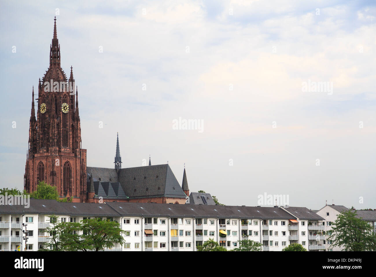 row of white modern apartments in front of a medieval church in Frankfurt, Germany Stock Photo