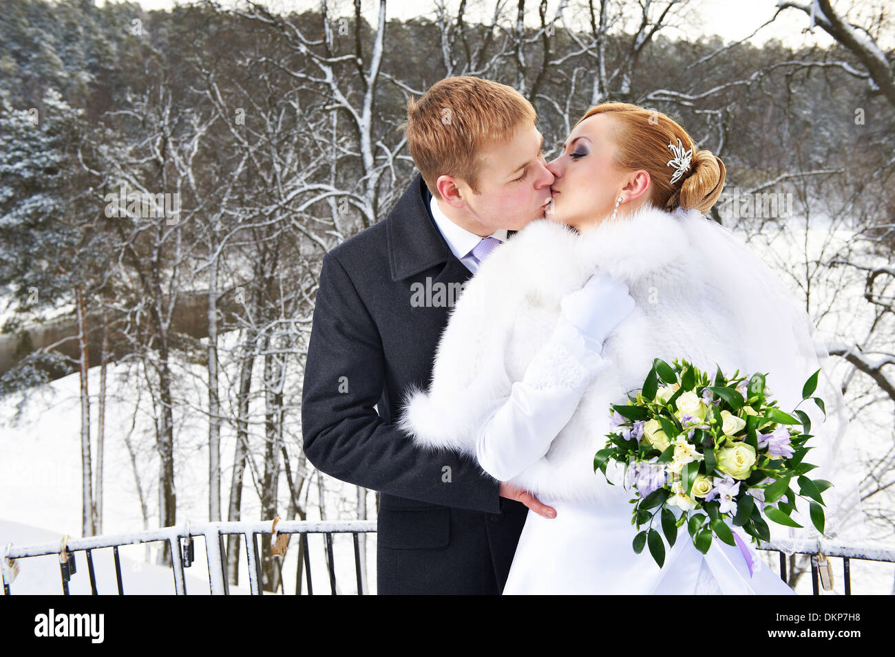 Romantic kiss happy bride and groom on winter wedding day Stock Photo ...