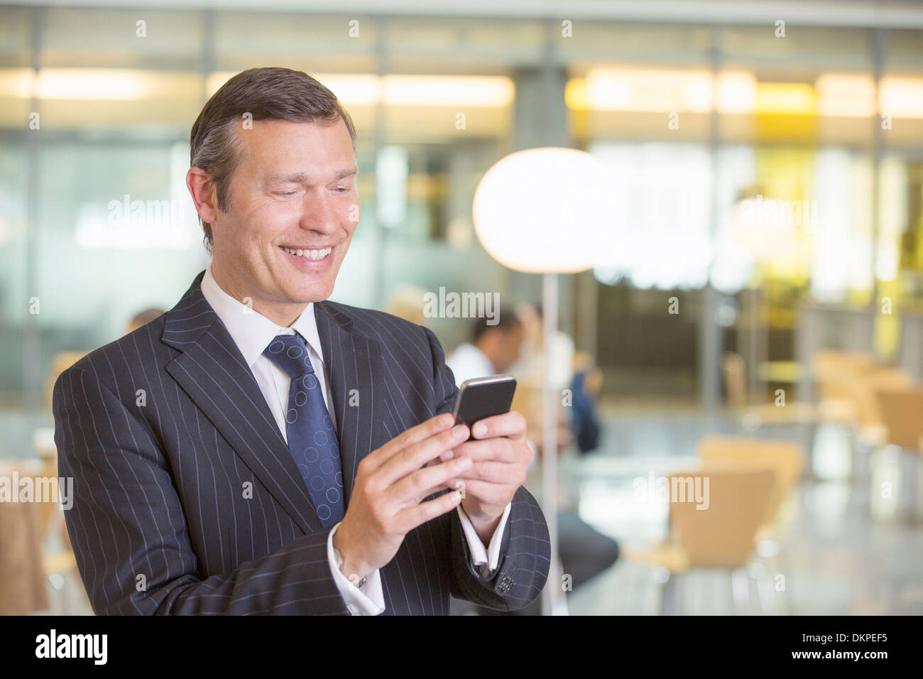 Businessman using cell phone in office Stock Photo