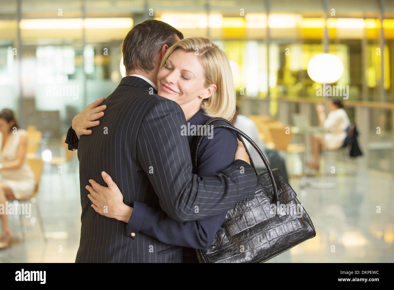 Business people hugging in office Stock Photo