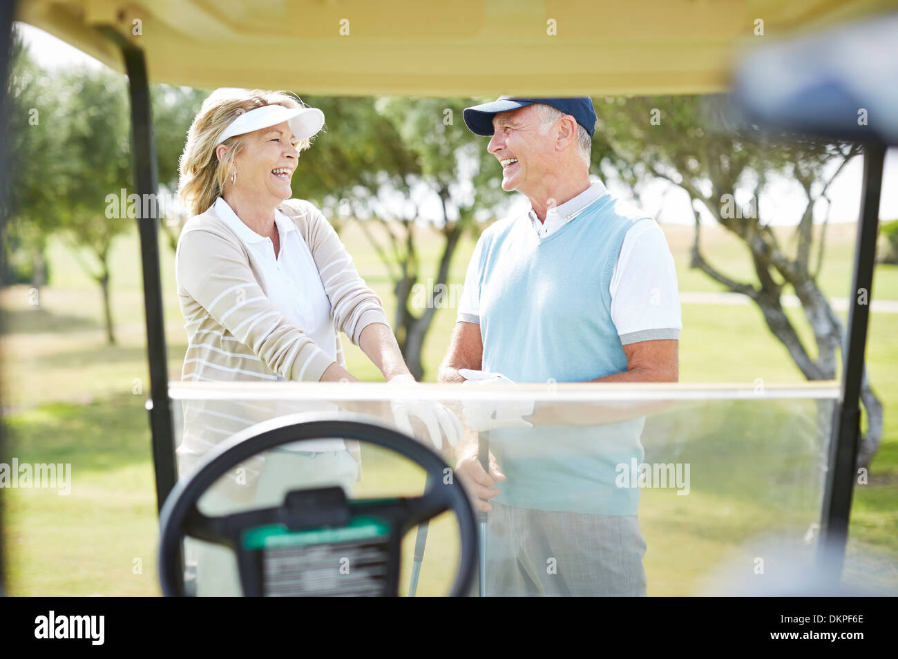 Senior couple laughing on golf course Stock Photo