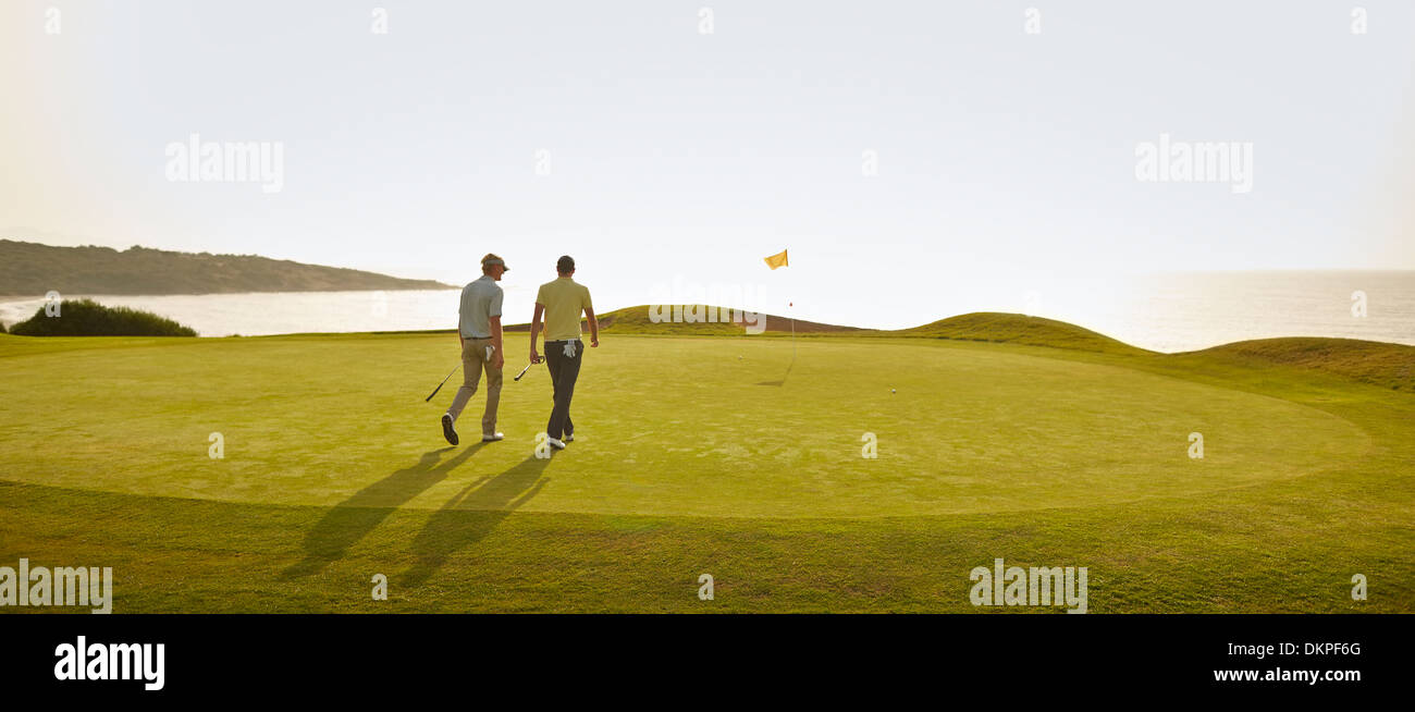Men walking on golf course Stock Photo