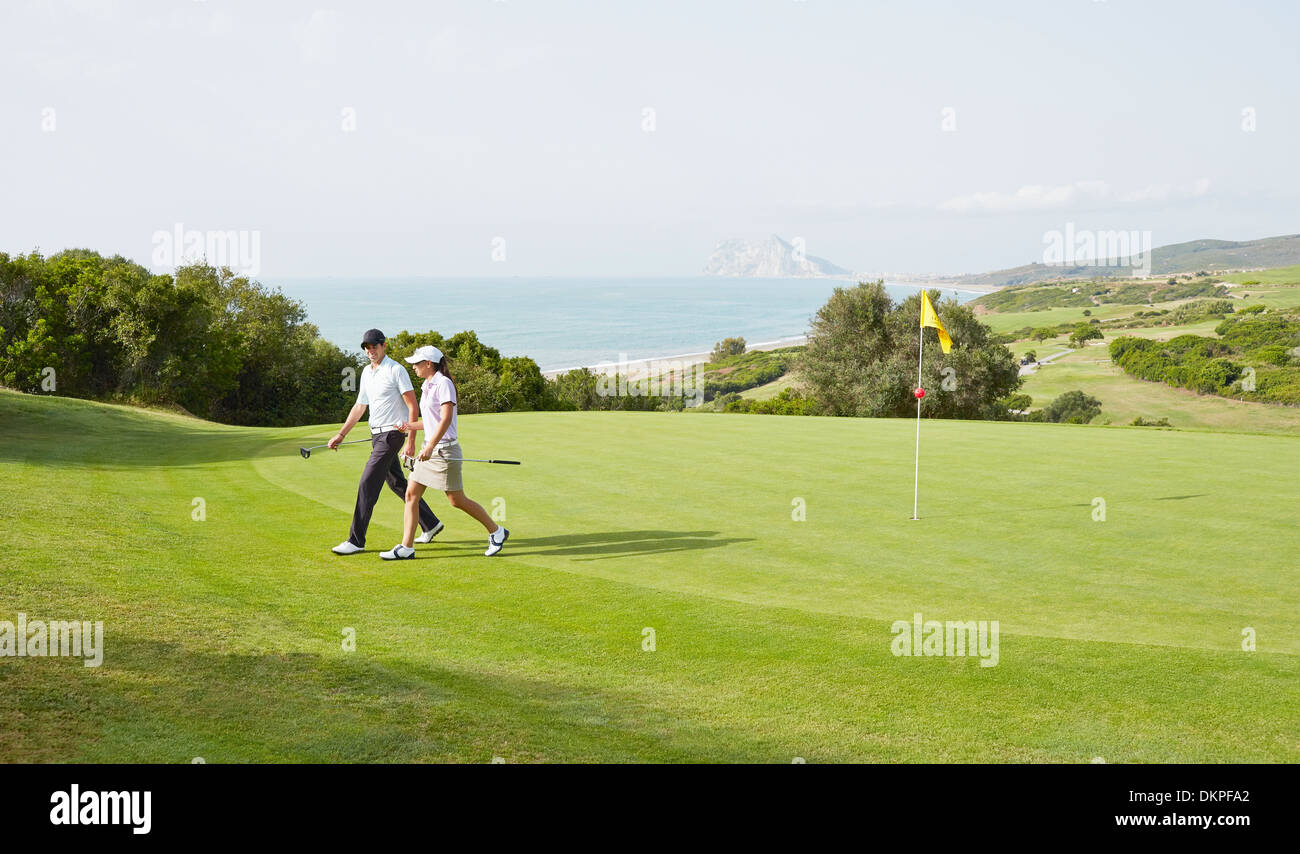 Couple walking on golf course Stock Photo