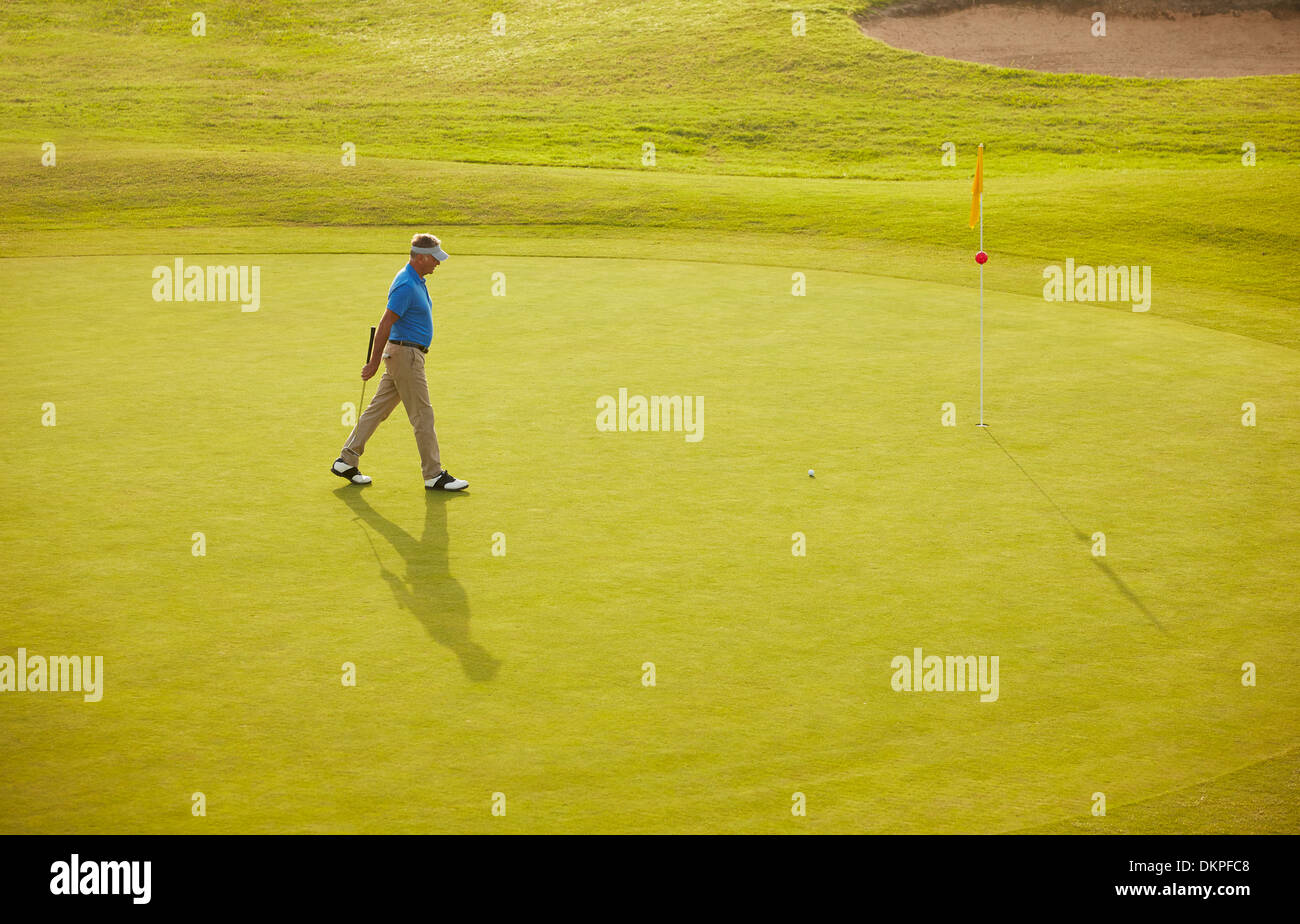 Man walking on golf course Stock Photo