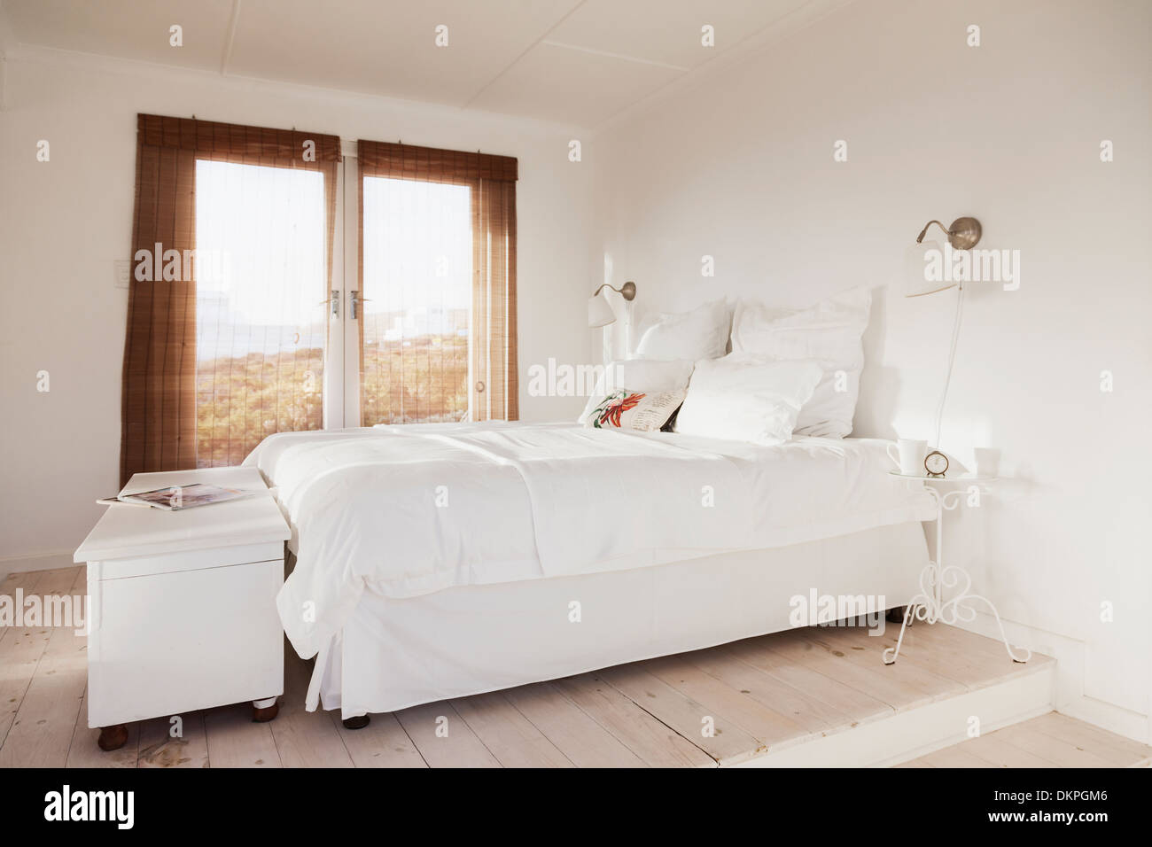 Bed in white bedroom Stock Photo