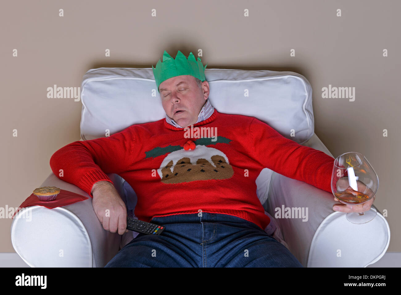 A Christmas tradition - Dad has fallen asleep in an armchair after dinner in front of the TV Stock Photo