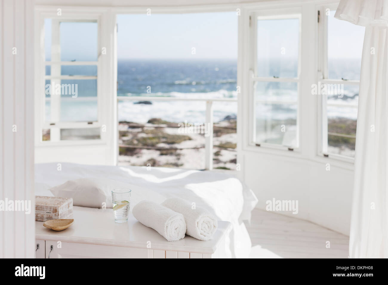 White bedroom overlooking ocean Stock Photo