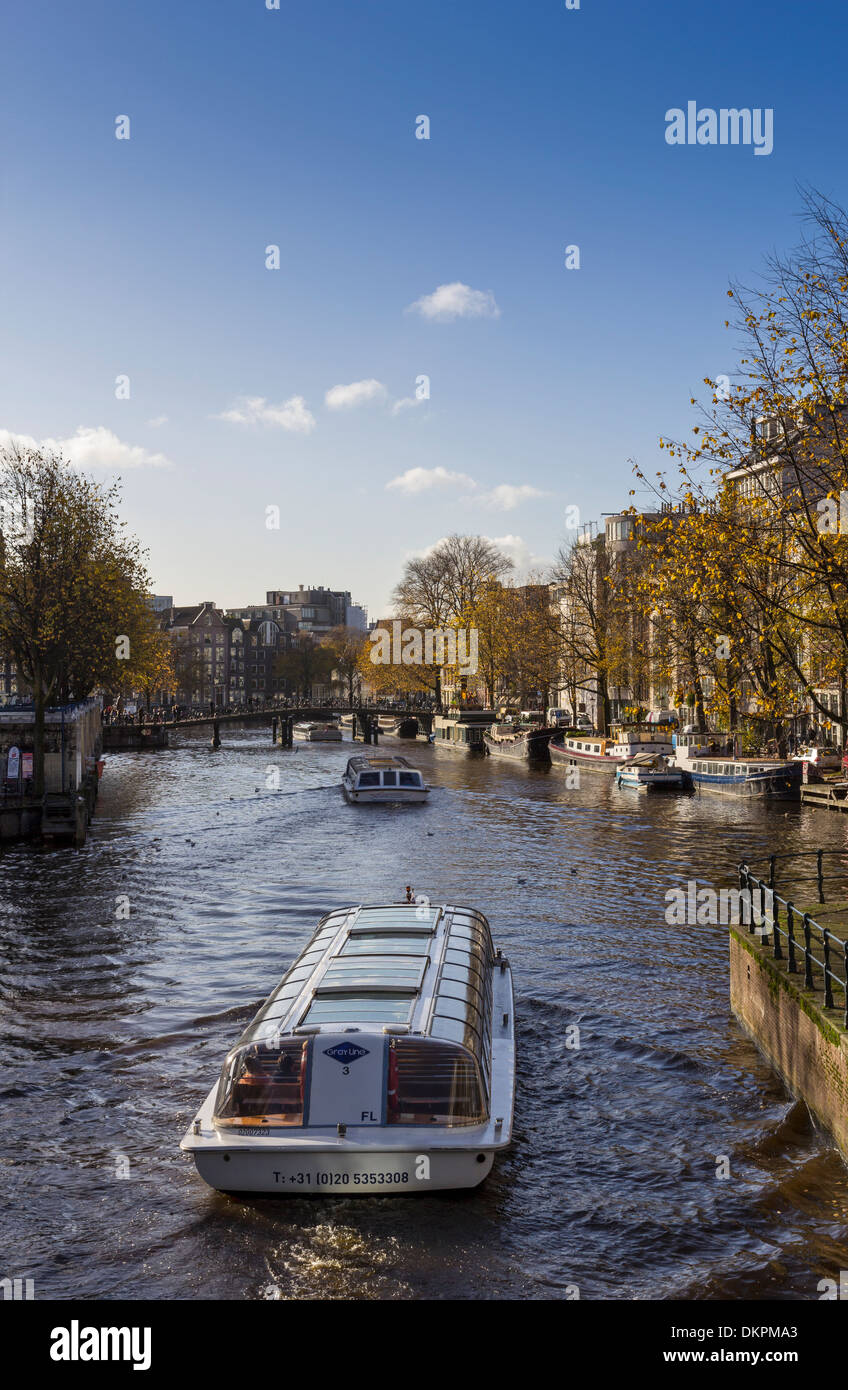 AMSTERDAM HOLLAND A CANAL WITH TOURIST SIGHTSEEING BOATS Stock Photo