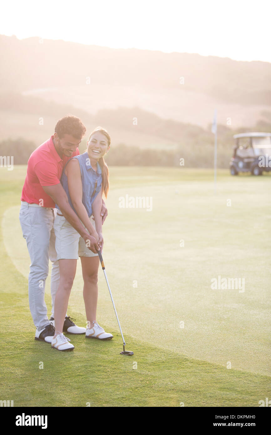 Man teaching woman to golf Stock Photo