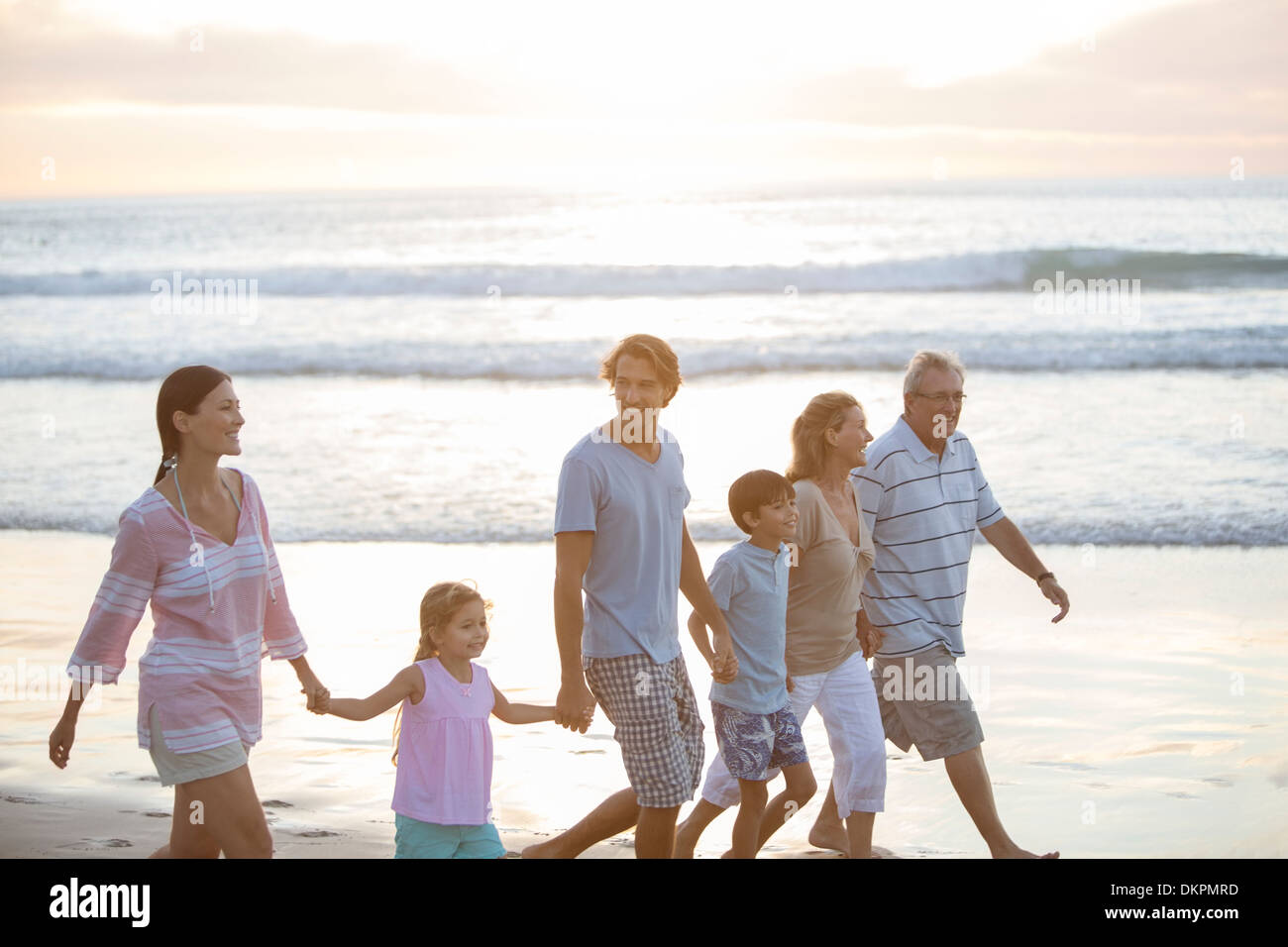 Multi-generation family walking together on beach Stock Photo