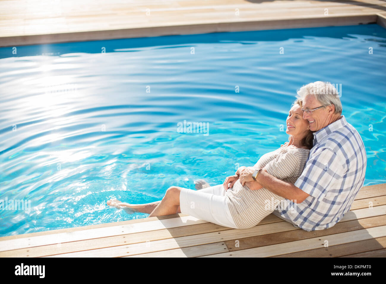 Senior couple relaxing by pool Stock Photo - Alamy