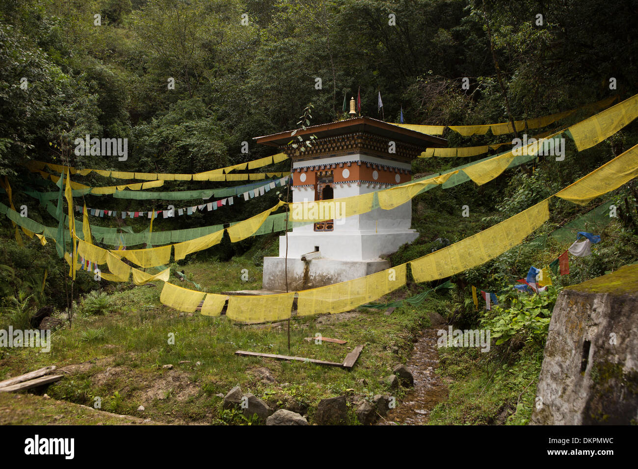 Bhutan, Trongsa, roadside water-powered prayer wheel decked with prayer flags Stock Photo