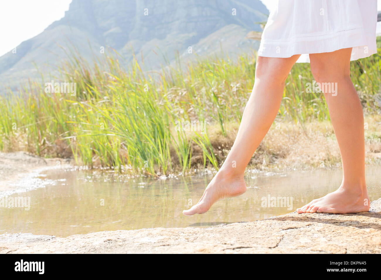 Woman dipping toe in rural pond Stock Photo Alamy