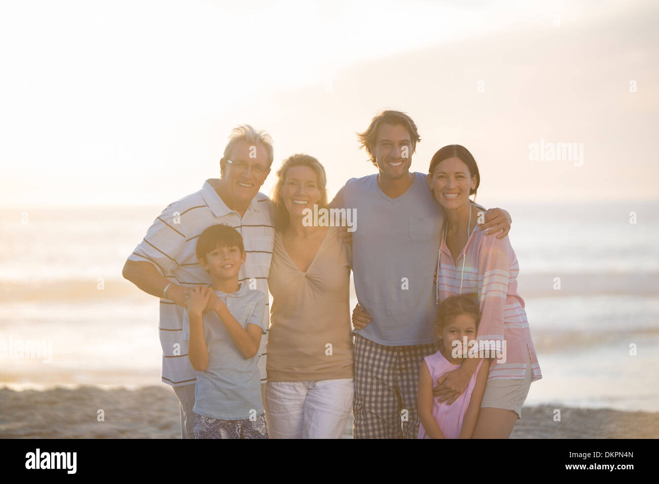 Family smiling together on beach Stock Photo