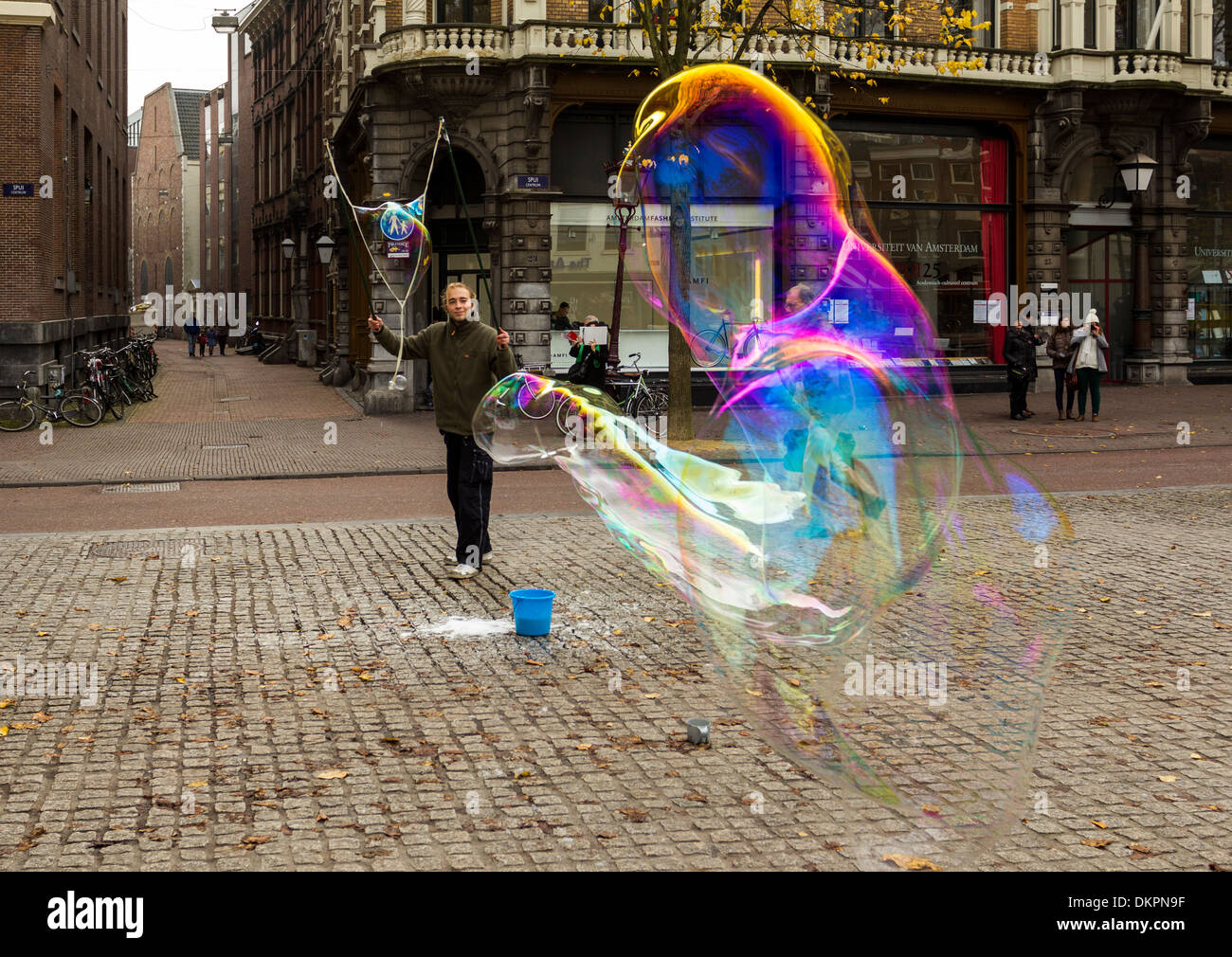 AMSTERDAM HUGE SOAP BUBBLES BLOWING IN THE STREET MADE BY A BUBBLE BLOWER AND HIS BUCKET OF SOAP SUDS Stock Photo