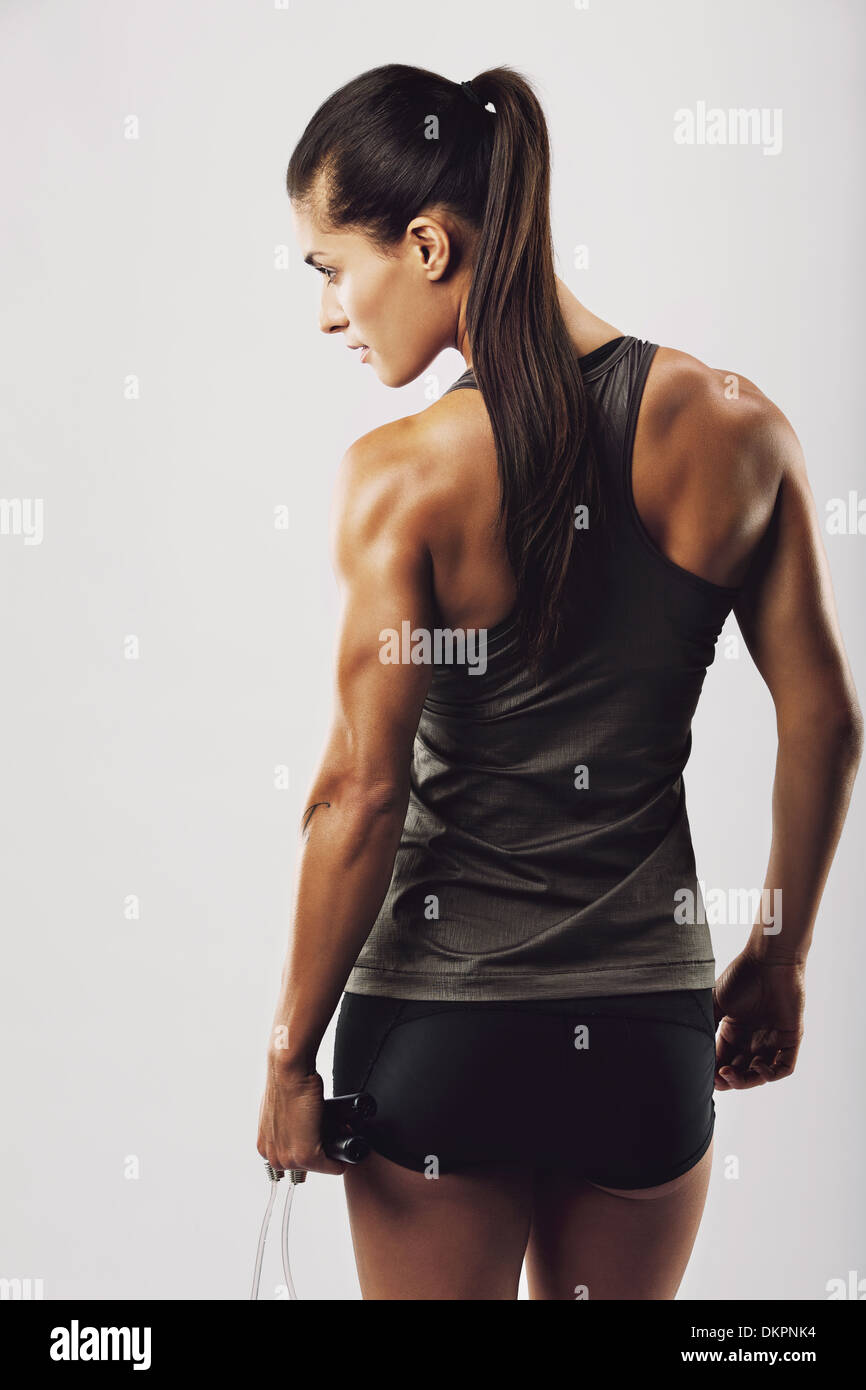 https://c8.alamy.com/comp/DKPNK4/rear-view-image-of-female-bodybuilder-holding-skipping-rope-looking-DKPNK4.jpg