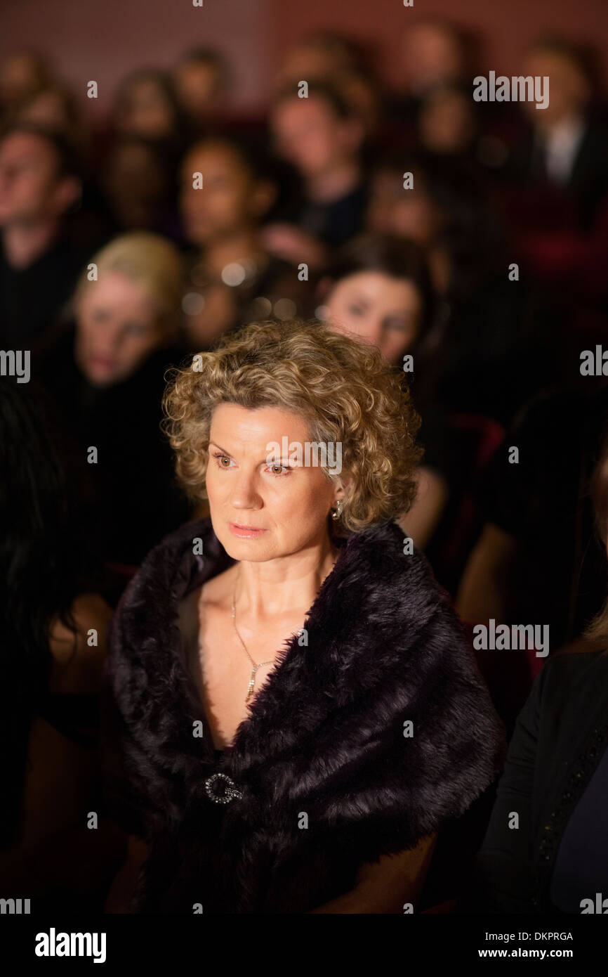 Serious woman in theater audience Stock Photo