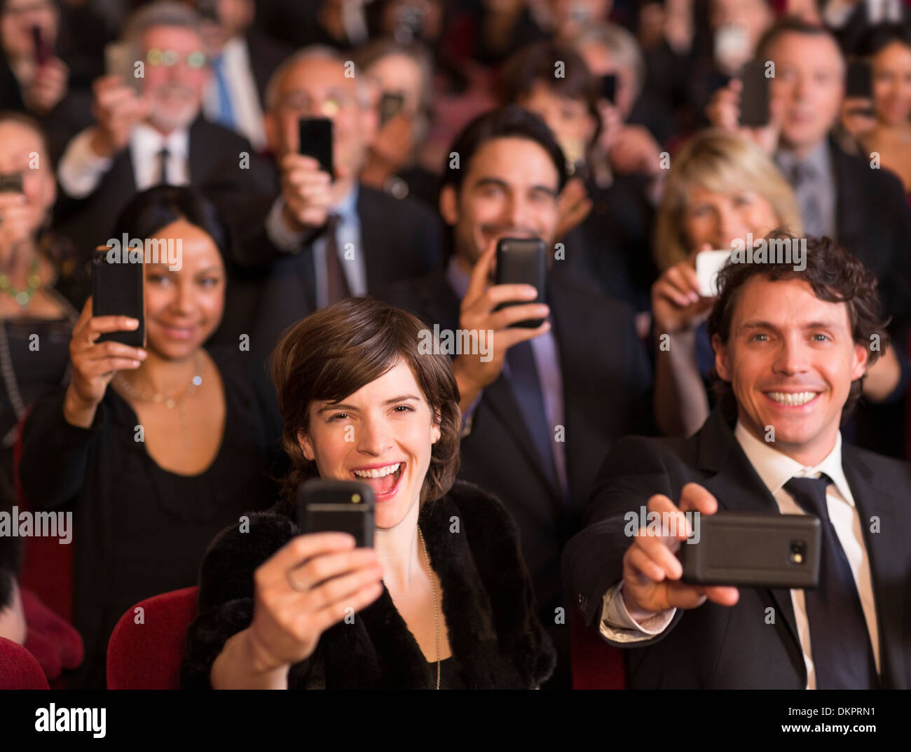 Enthusiastic theater audience videoing performance with smart phones Stock Photo