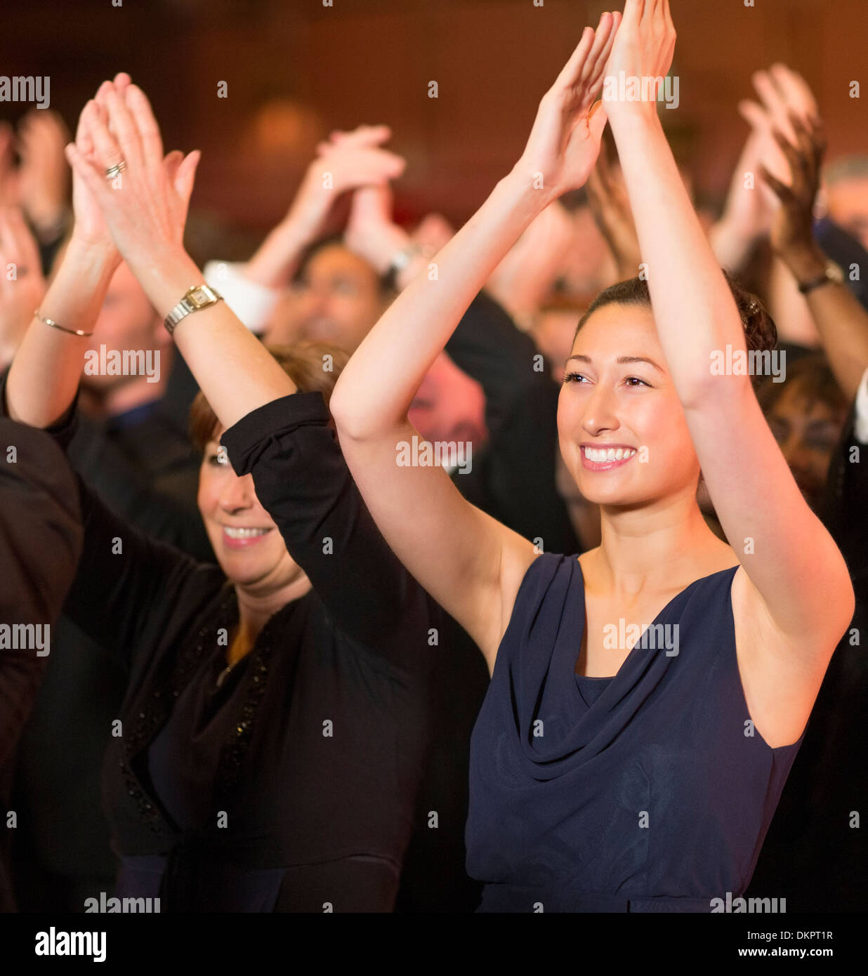 Enthusiastic women clapping in theater audience Stock Photo