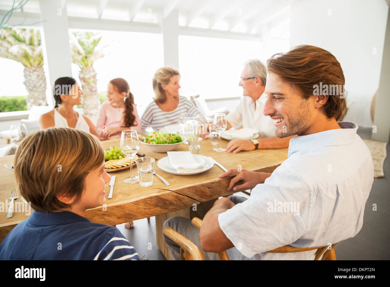 Multi-generation family eating together at table Stock Photo