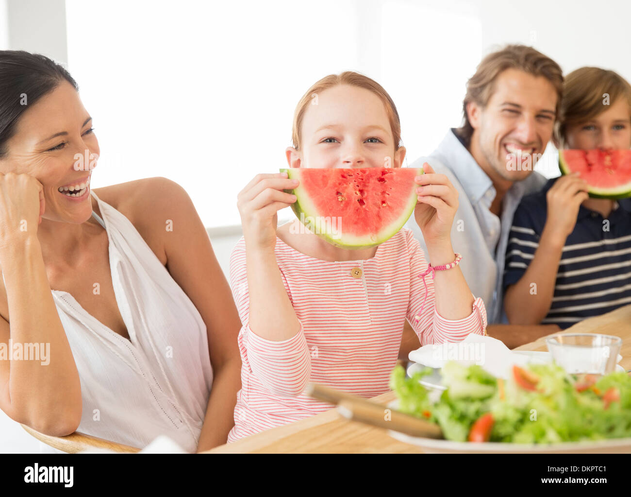 Family eating watermelon at table Stock Photo