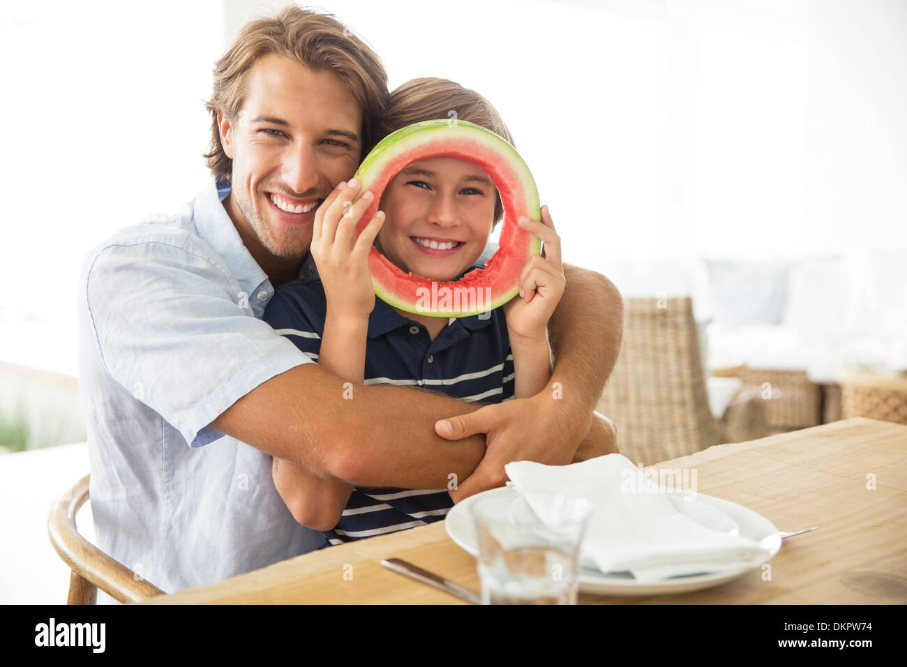 Father and son playing with food at table Stock Photo
