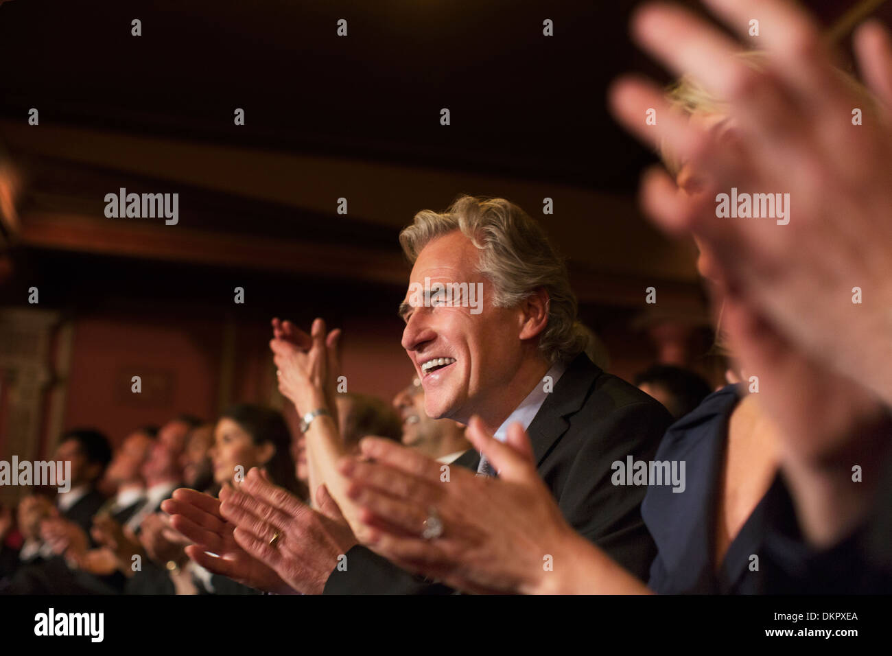 Enthusiastic man clapping in theater audience Stock Photo