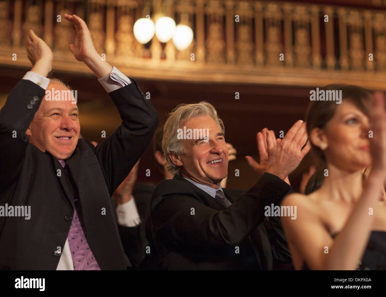 Enthusiastic men clapping in theater audience Stock Photo