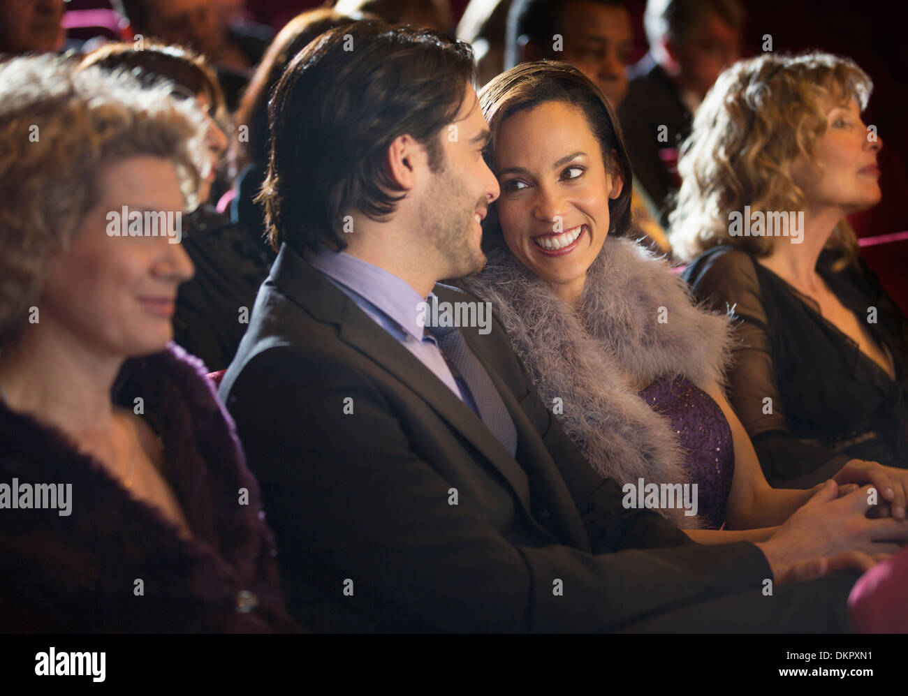 Smiling couple talking in theater audience Stock Photo