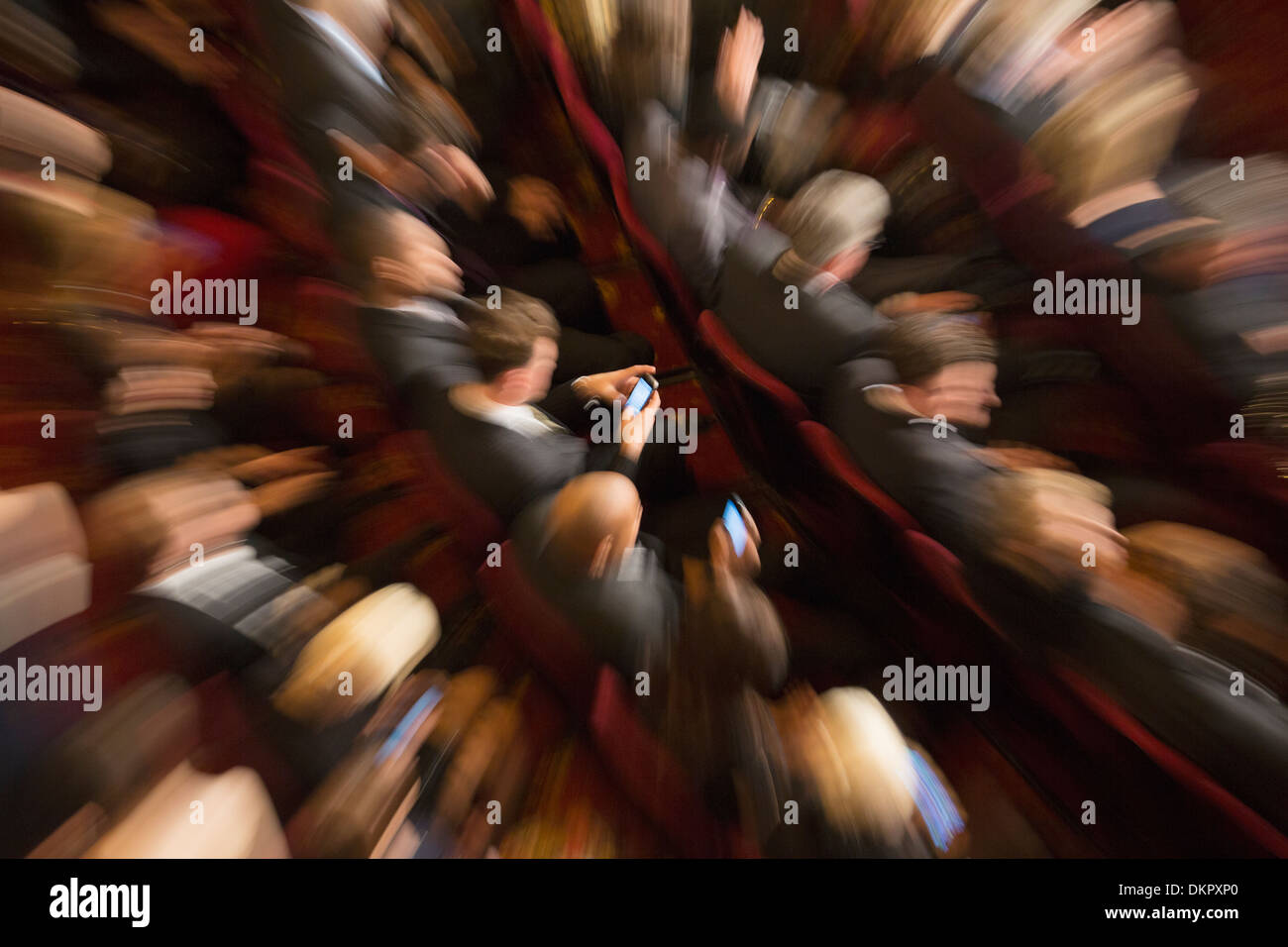 Defocused view of men using cell phones in theater audience Stock Photo